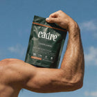 Cadre creatine gummies held during arm flex highlighting muscle strength and daily creatine supplementation